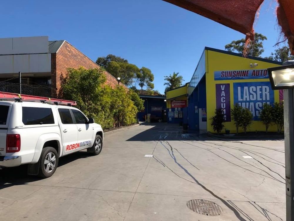 A White Truck Is Parked In Front Of A Building That Says Laser Wash — Robon Electrical In Holloways Beach, QLD