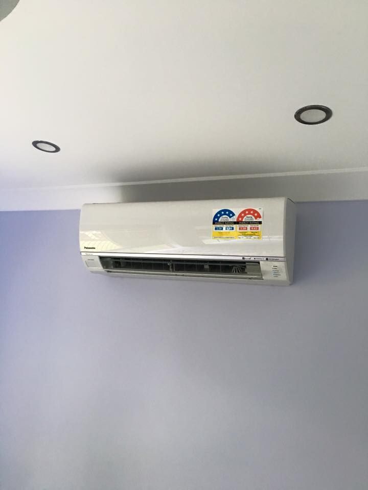 A White Air Conditioner Is Hanging From The Ceiling In A Room — Robon Electrical In Holloways Beach, QLD