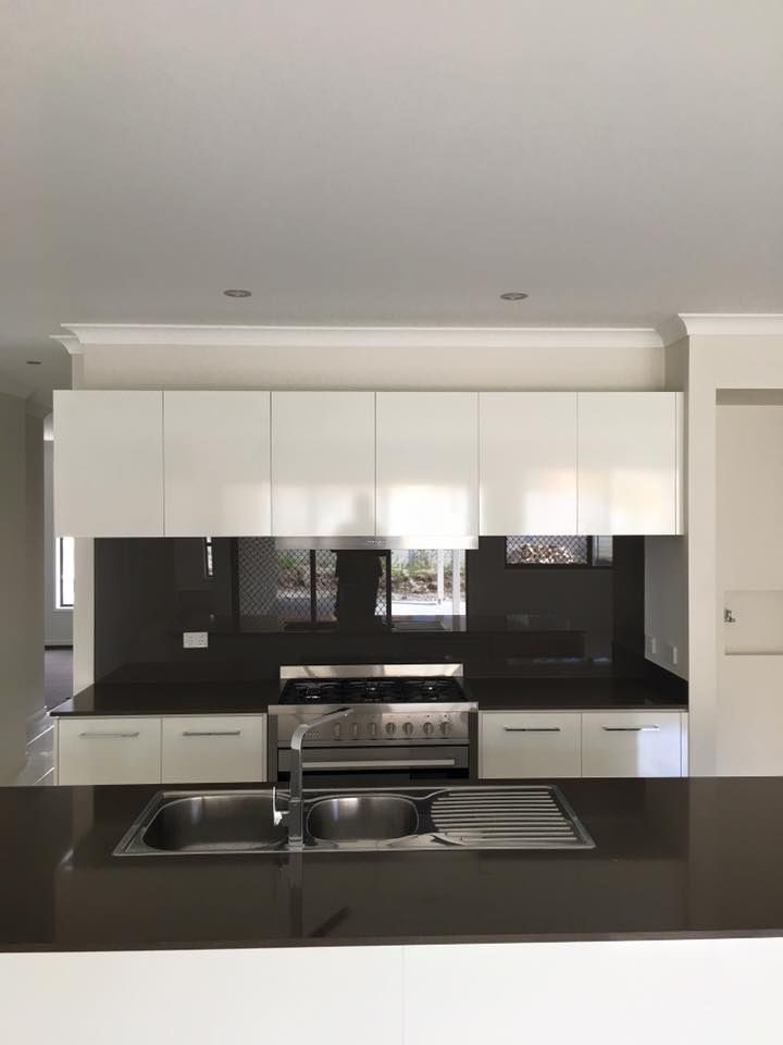 A Kitchen With A Sink, Stove, And Cabinets — Robon Electrical In Holloways Beach, QLD