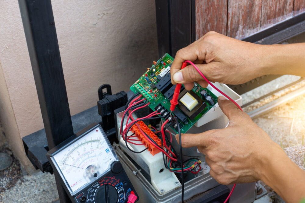 A Person Is Using A Multimeter To Test A Circuit Board — Robon Electrical In Cairns, QLD