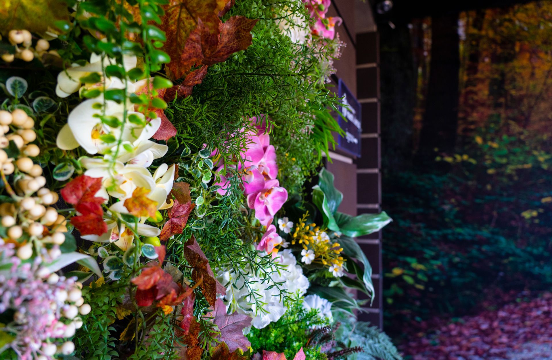Un mazzo di fiori e foglie è appeso a una parete.
