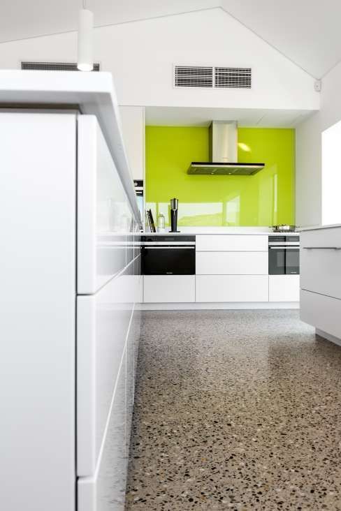 A kitchen with white cabinets and a yellow wall.