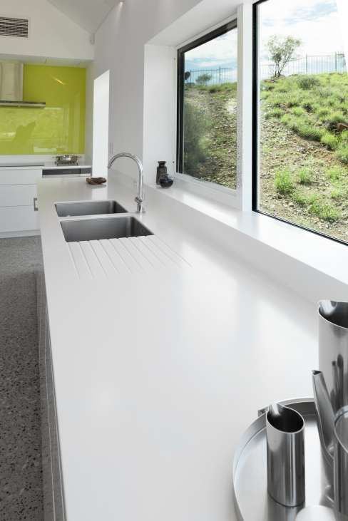 A kitchen with two sinks and a window with a view of a field.