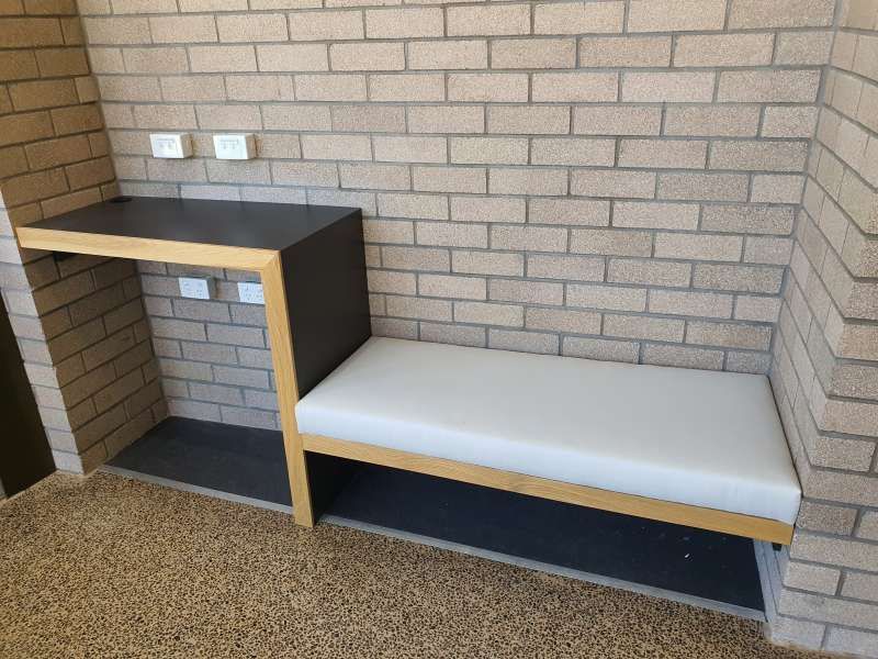 A brick wall with a bench in front of it