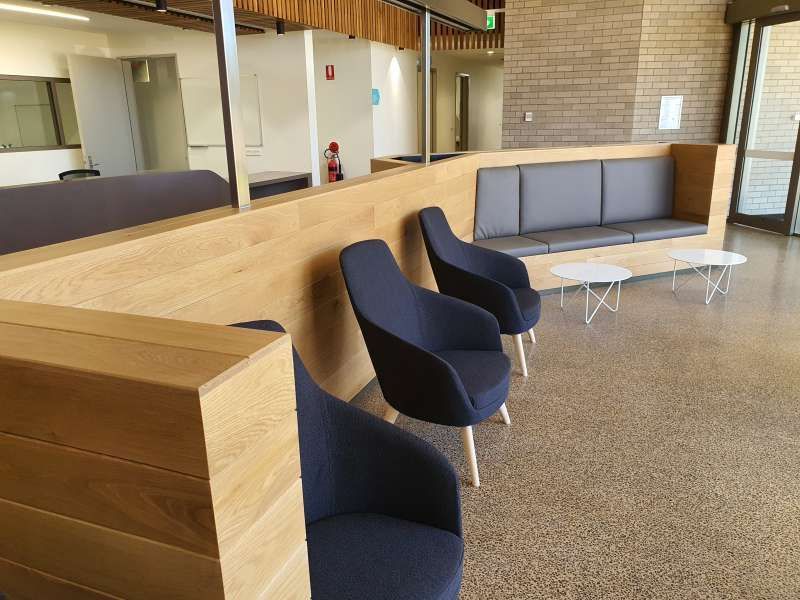 A waiting room with chairs , tables and a couch.