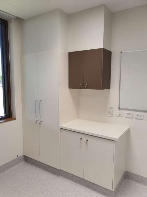 A room with white cabinets and a white board on the wall.