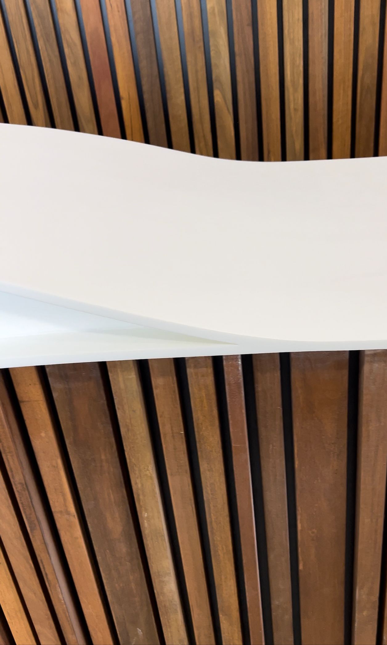 A white piece of paper is sitting on top of a wooden table.