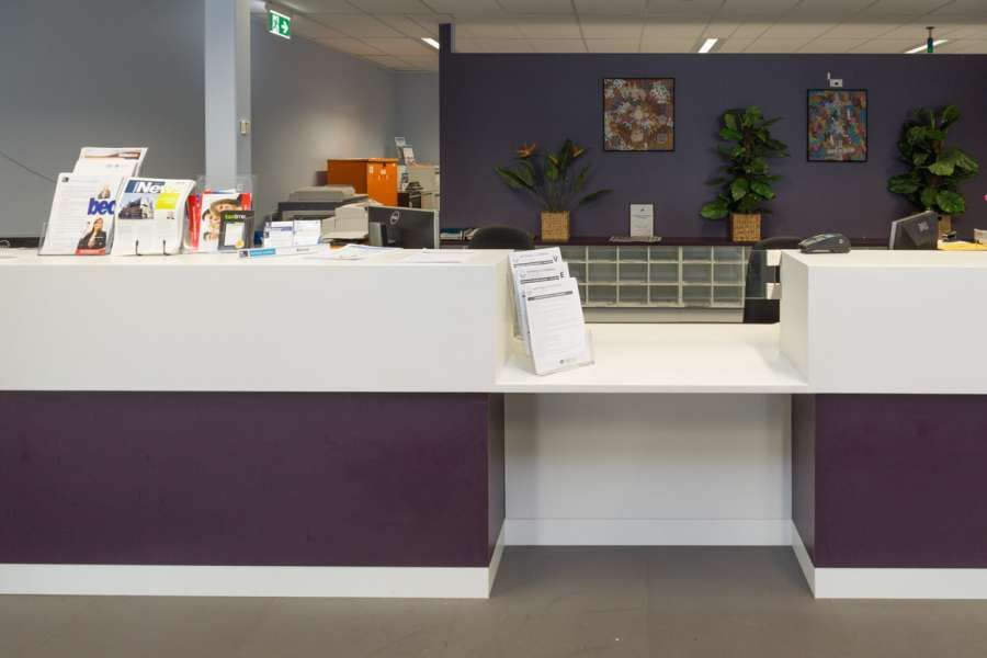 A white and purple counter in a room with a purple wall.