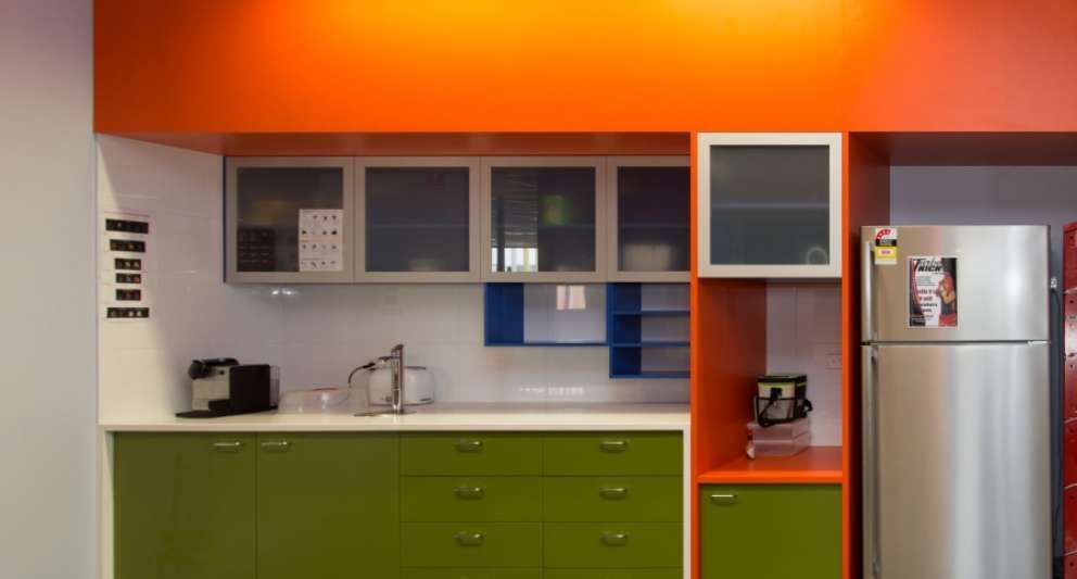 A kitchen with green cabinets and a stainless steel refrigerator