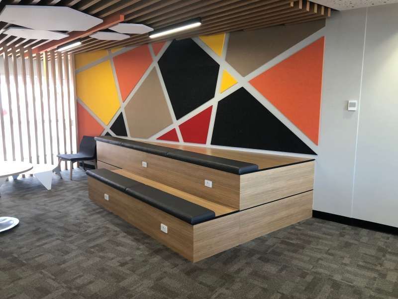 A room with a wooden bench and a colorful wall