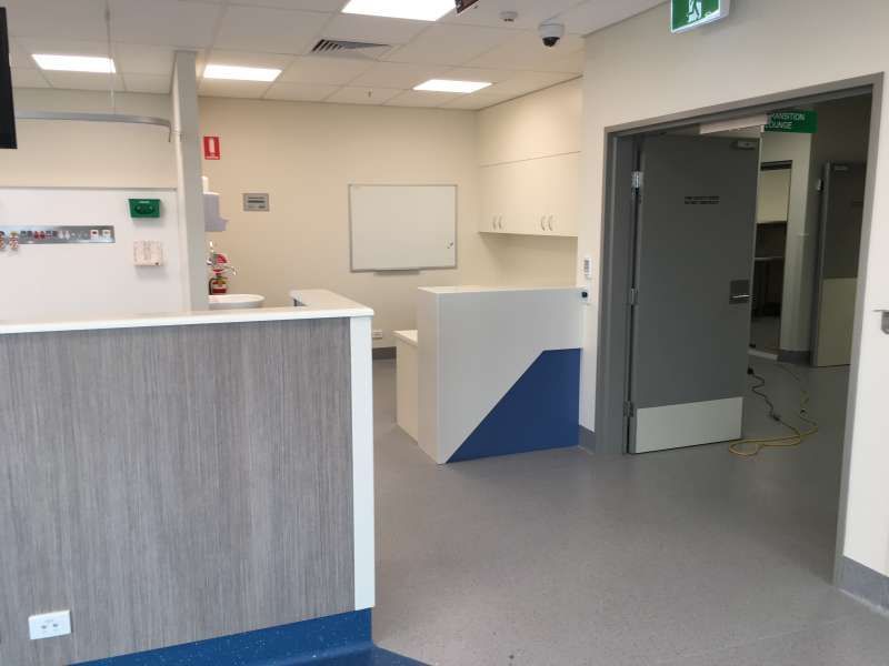 A hospital room with a counter and a door