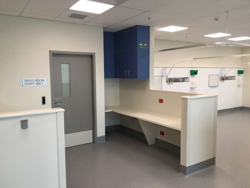 A hospital room with a desk and a door