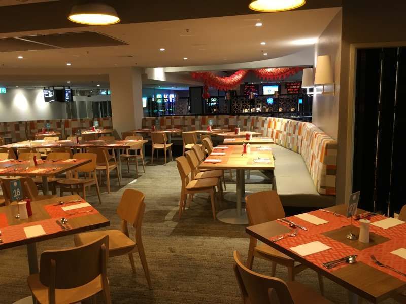 A restaurant filled with tables and chairs and a couch.