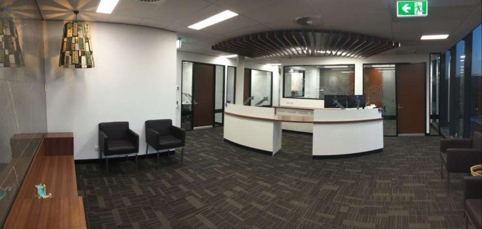 A large room with a reception desk and chairs in it.
