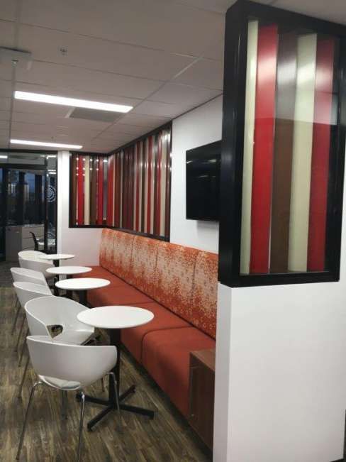A room with tables and chairs and a red couch