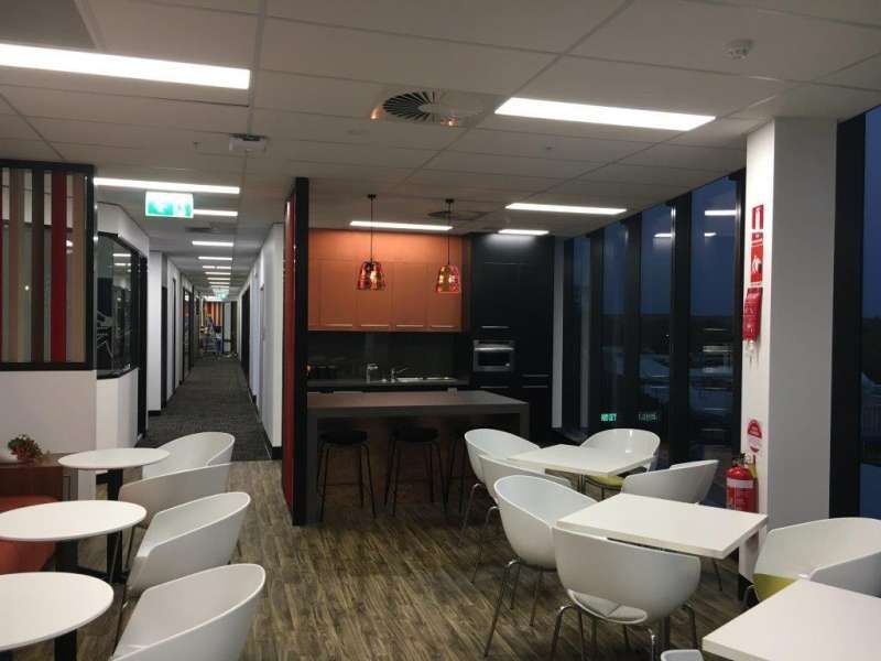 A room with tables and chairs and a fire extinguisher on the wall