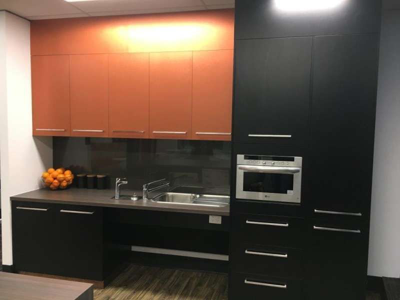 A kitchen with black cabinets and orange cabinets