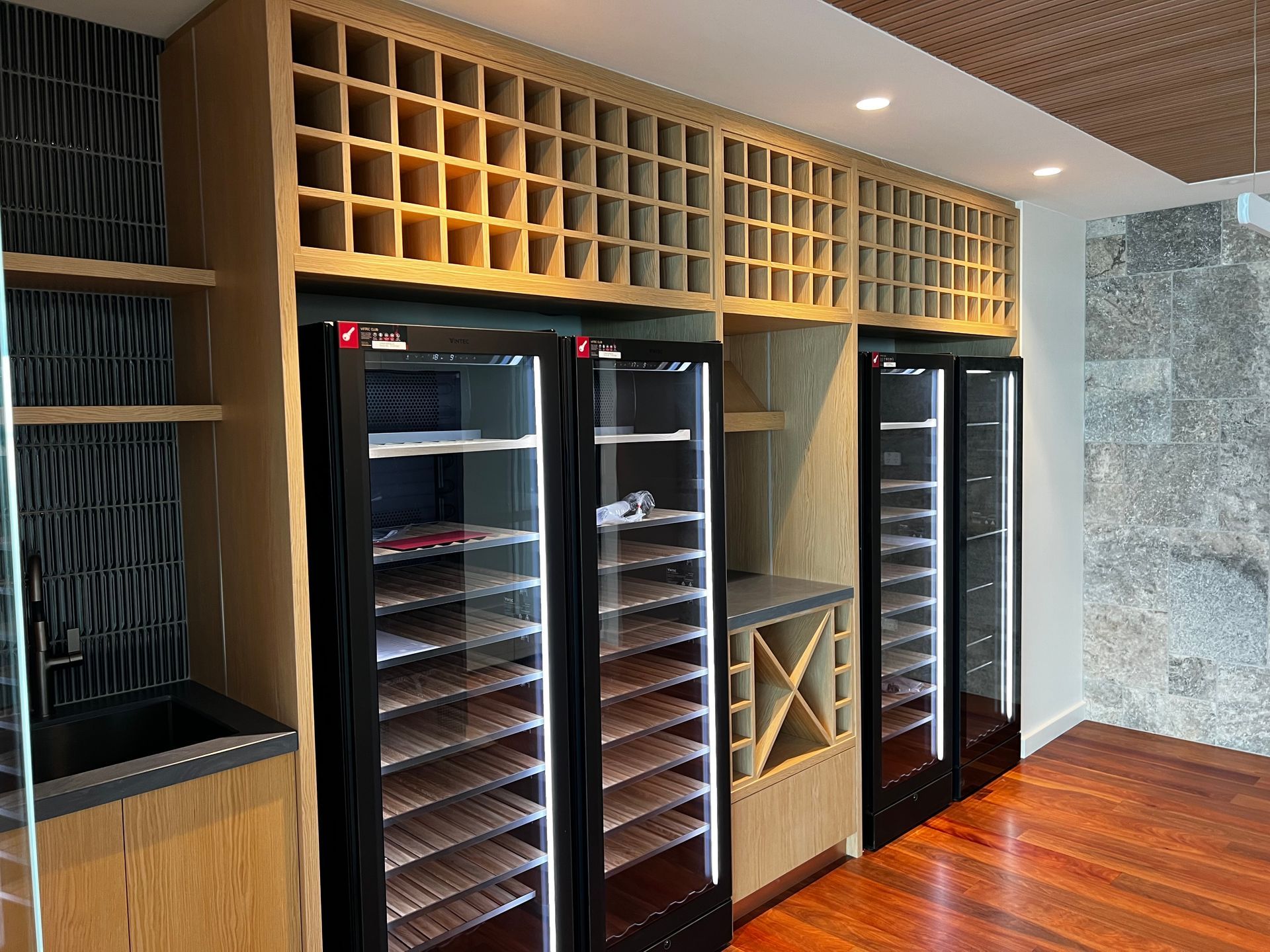 A room with a lot of wine coolers and shelves