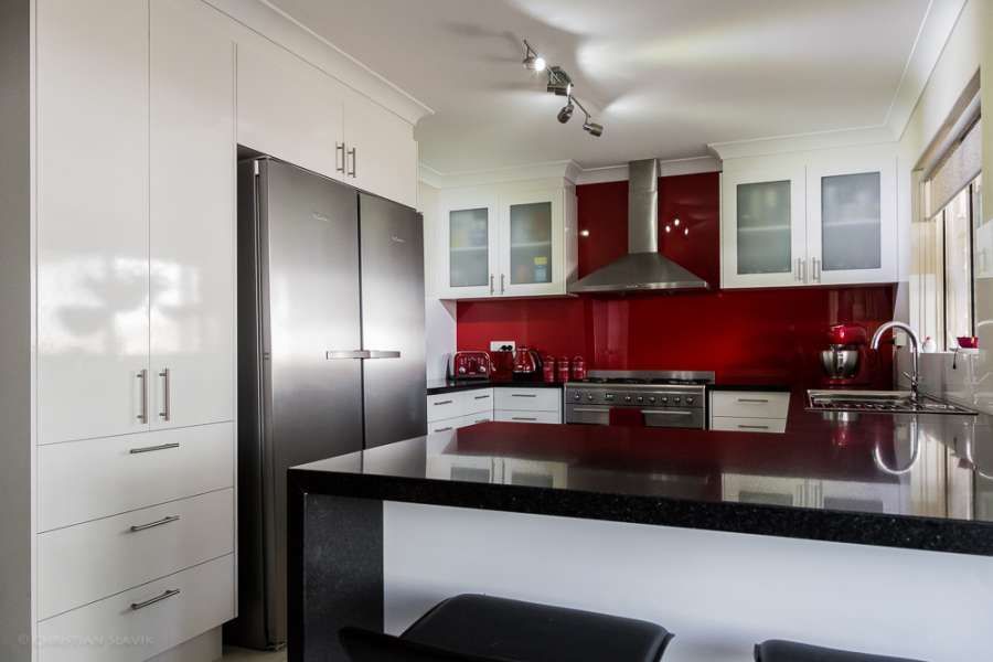 A kitchen with white cabinets and black counter tops