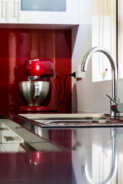 A kitchen with a red mixer and a sink