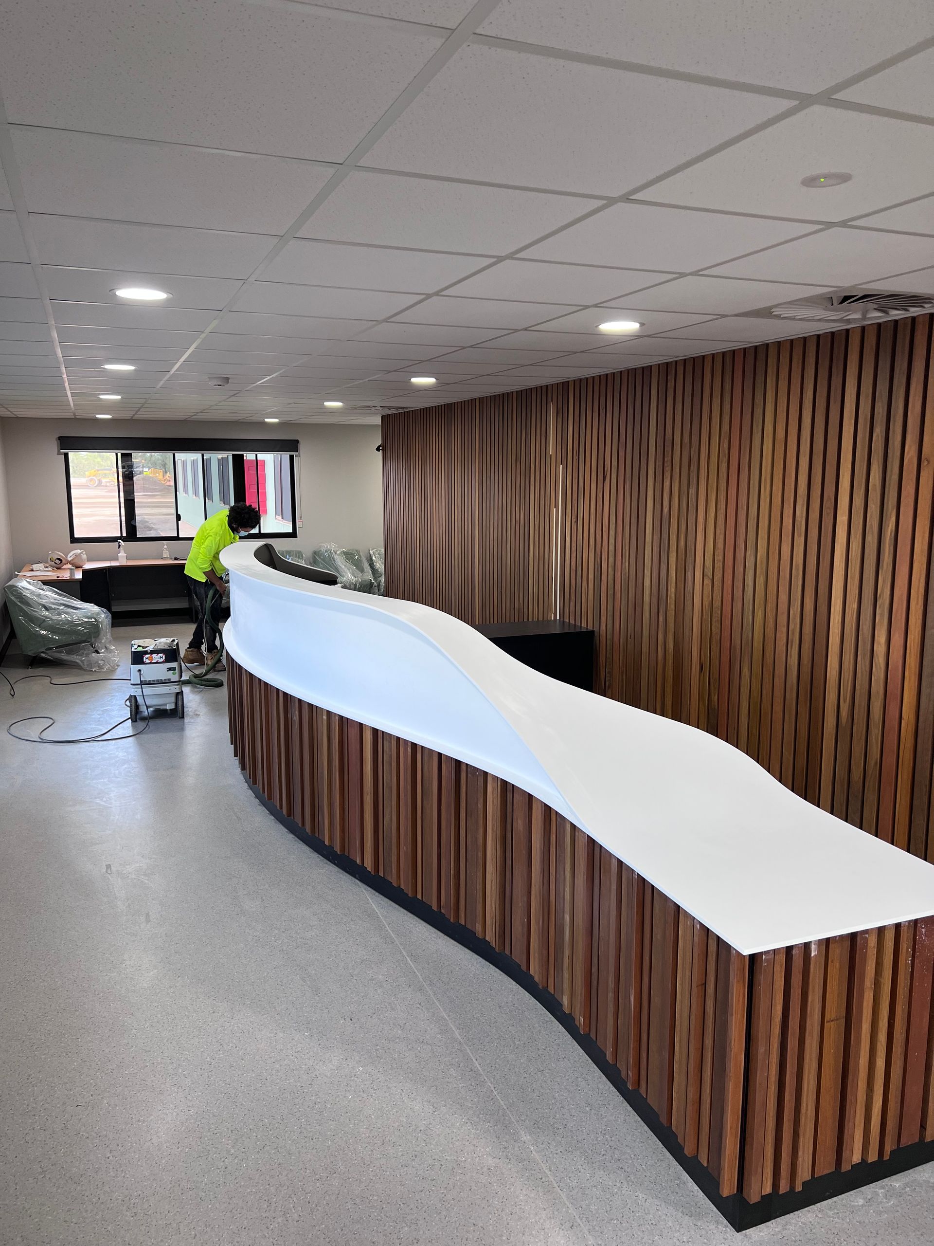 A large room with a curved white counter and wooden walls