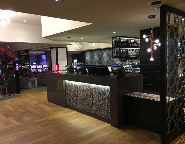 A hotel lobby with a counter and a bar.
