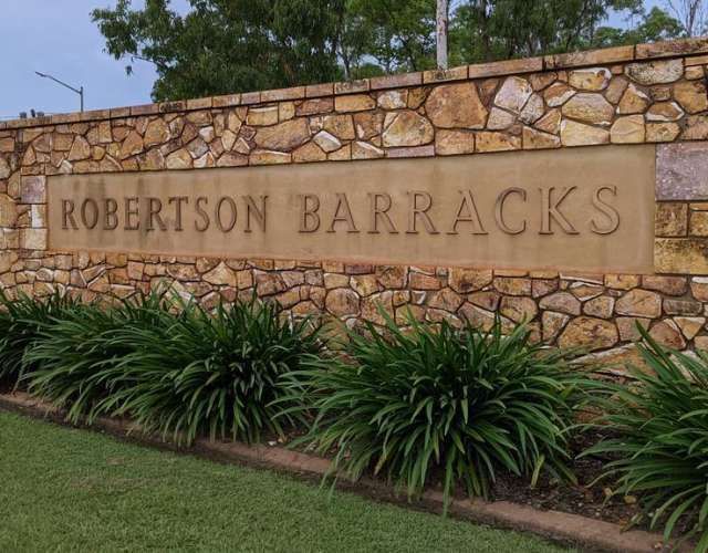 A stone wall with a sign that says robertson barracks
