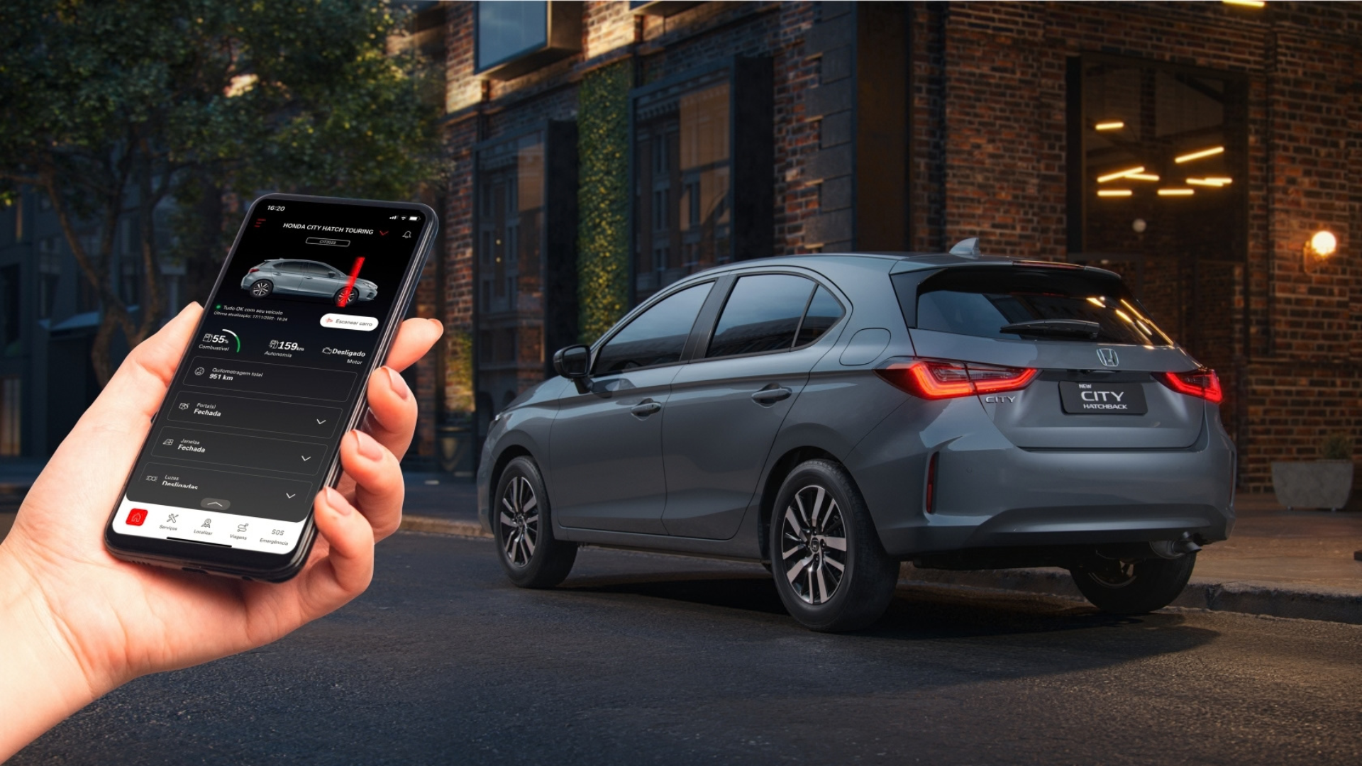 Hand holding a smartphone controlling a gray SUV parked outside a brick building at dusk