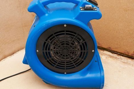 A blue and black blower is sitting on a table.