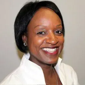 Smiling woman in white blouse against a neutral background