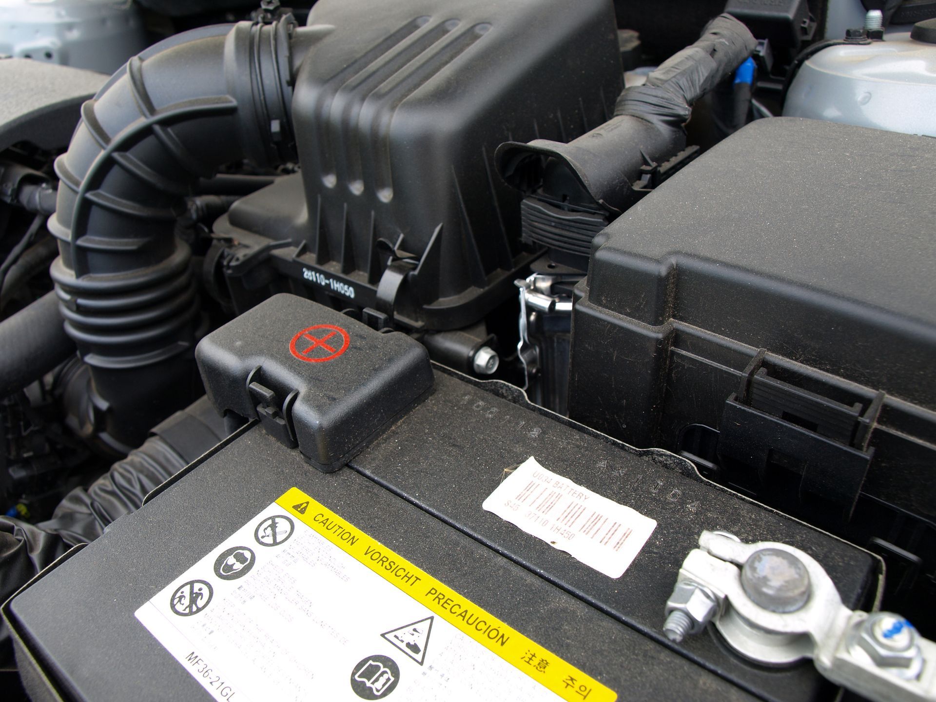 Auto mechanic replacing car battery.
