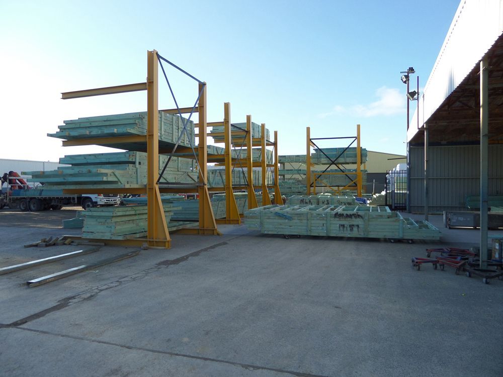 A Warehouse Filled With Lots of Stacked Pieces of Wood — Hume, ACT — Universal Trusses