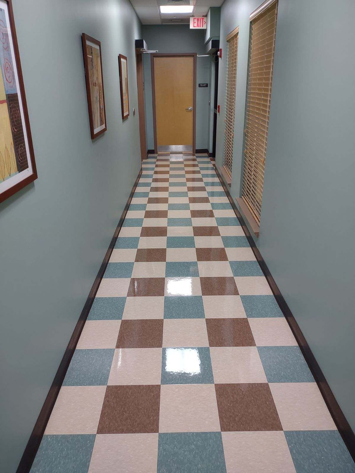 A hallway with a checkered floor and a door