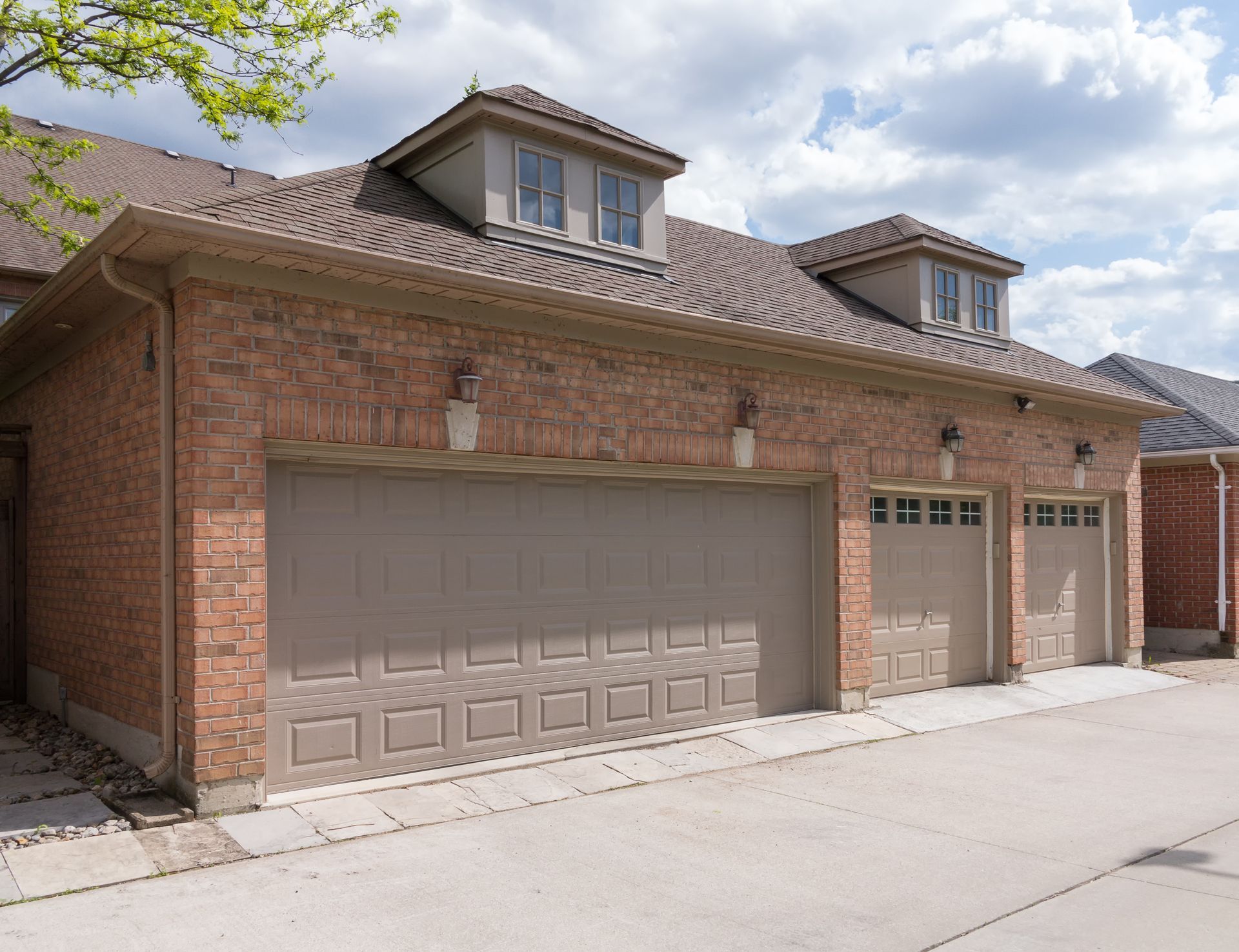 Modern residential garage door on a brick home with a concrete driveway