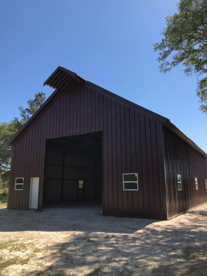 A large brown barn with a blue sky in the background