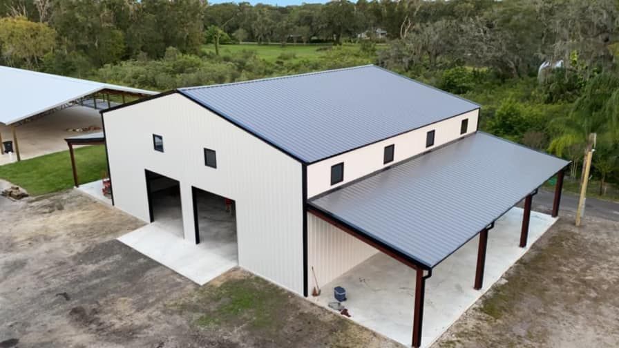 An aerial view of a large metal building with a black roof.