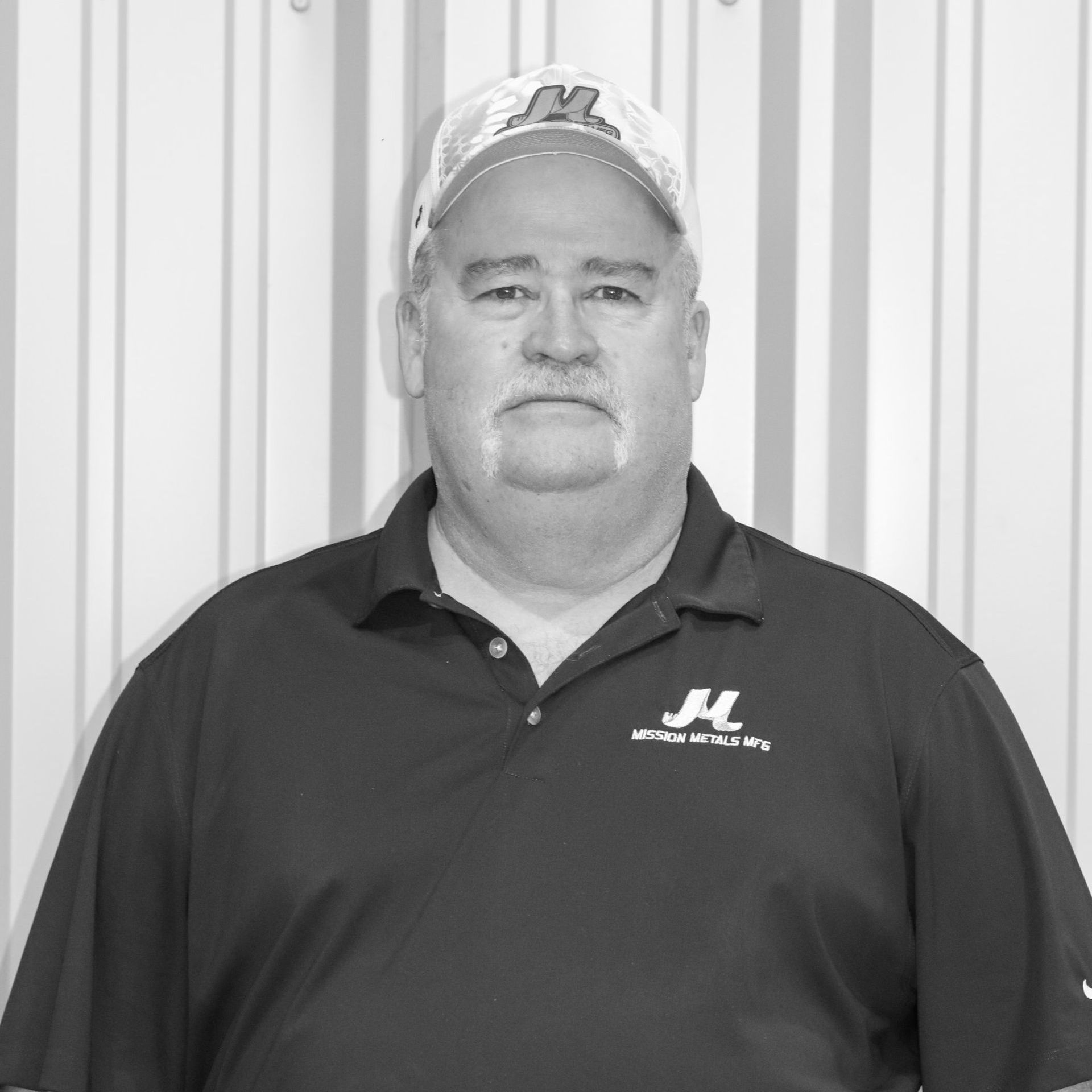 A man wearing a hat and a shirt with the letter m on it