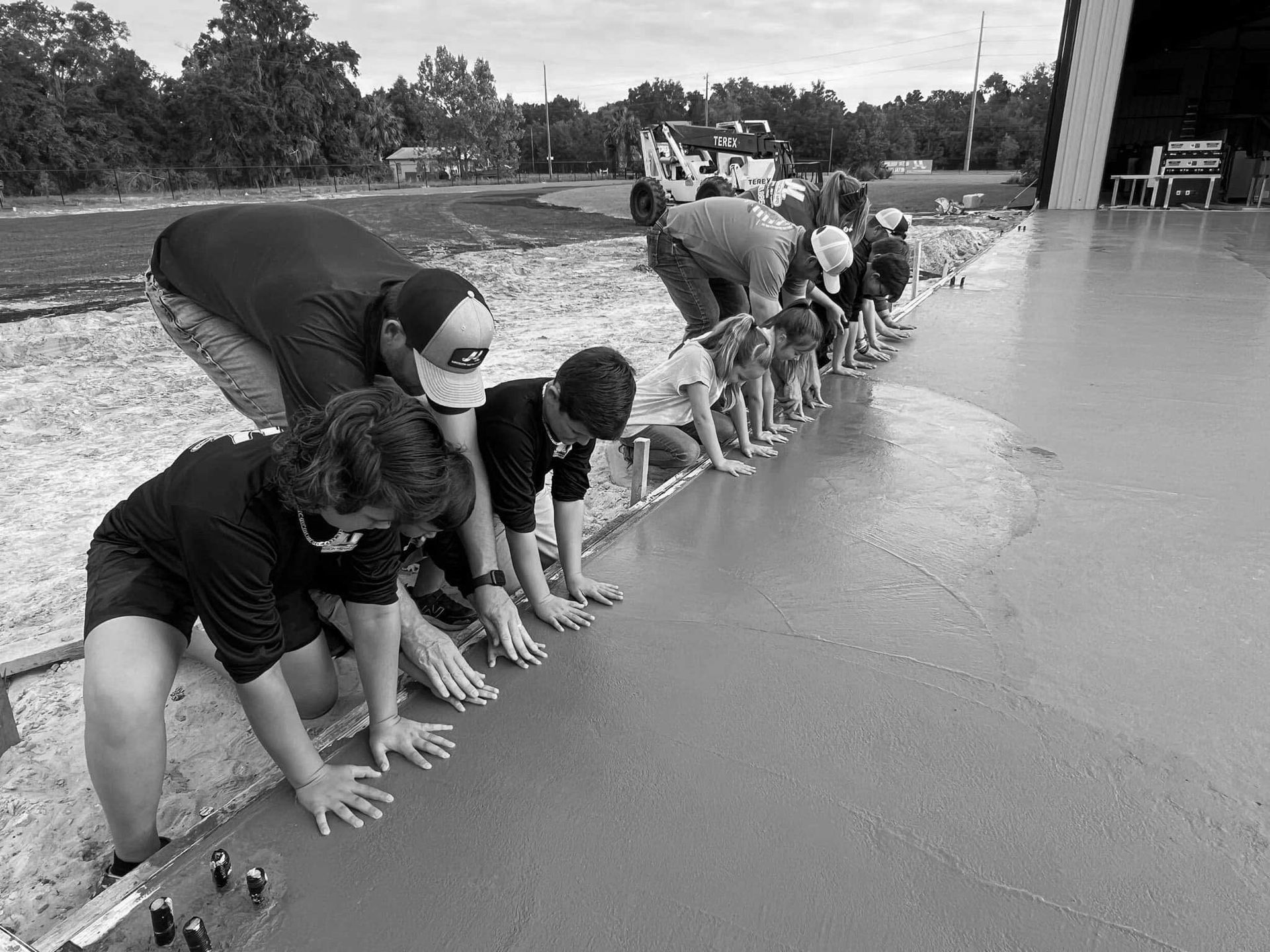 A group of people are kneeling down on a concrete surface.