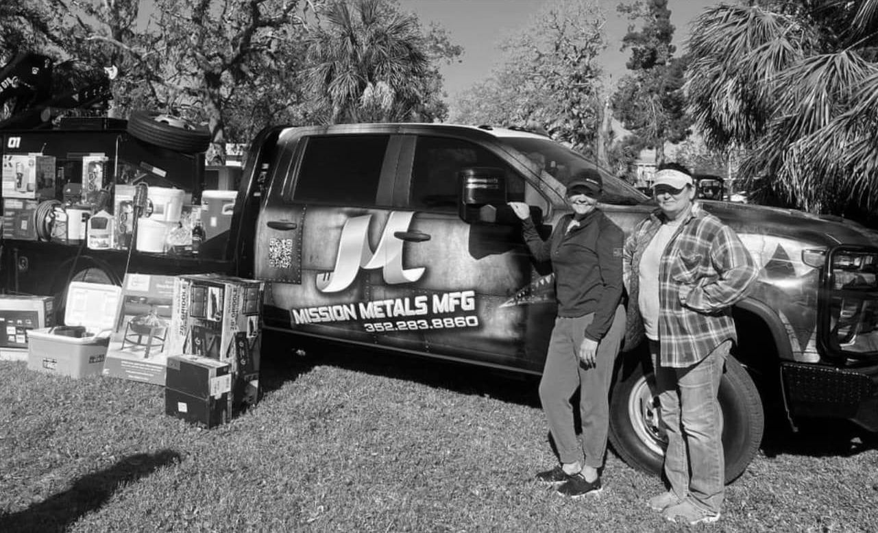 Two people are standing in front of a truck.