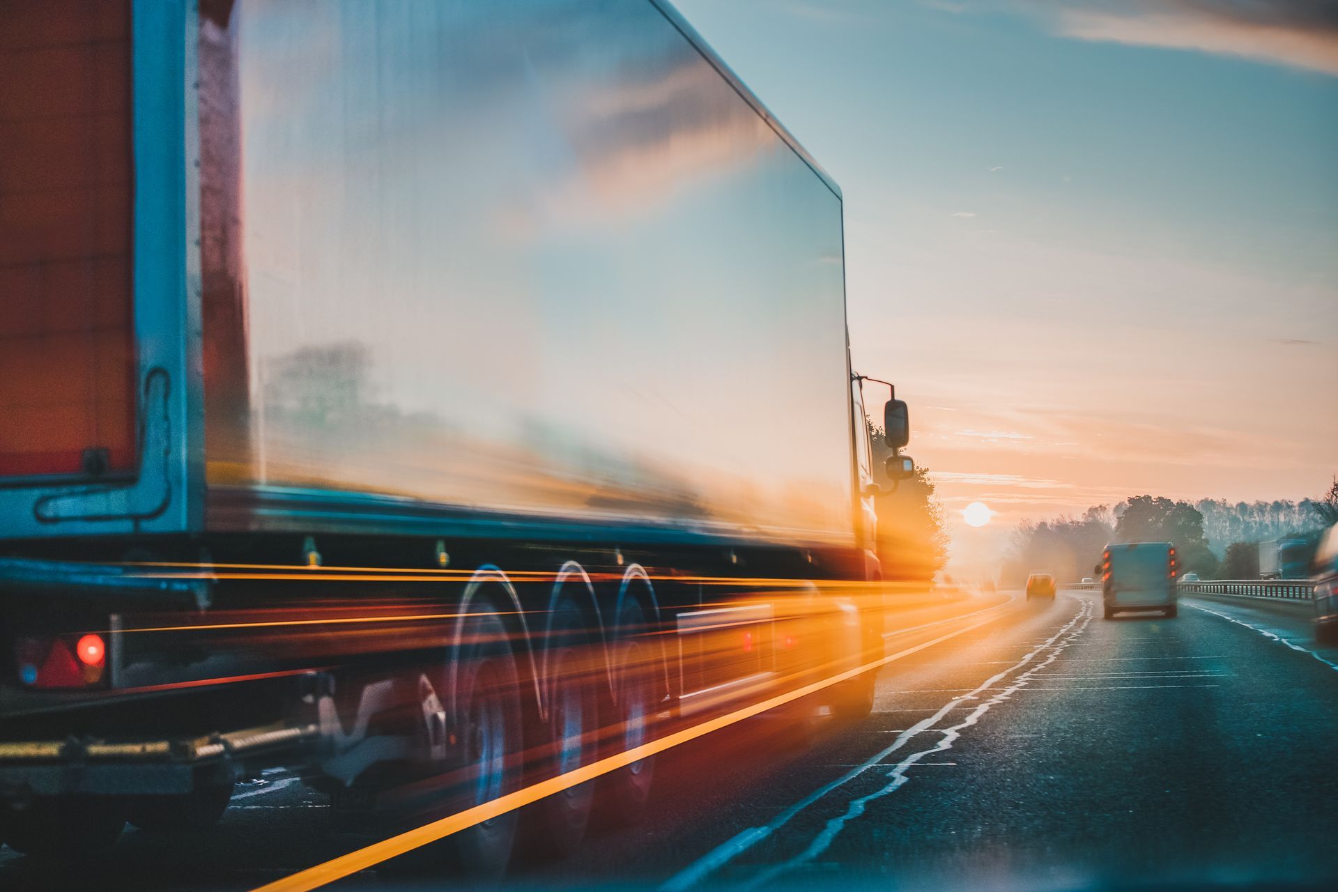 un camion percorre una autostrada al tramonto.