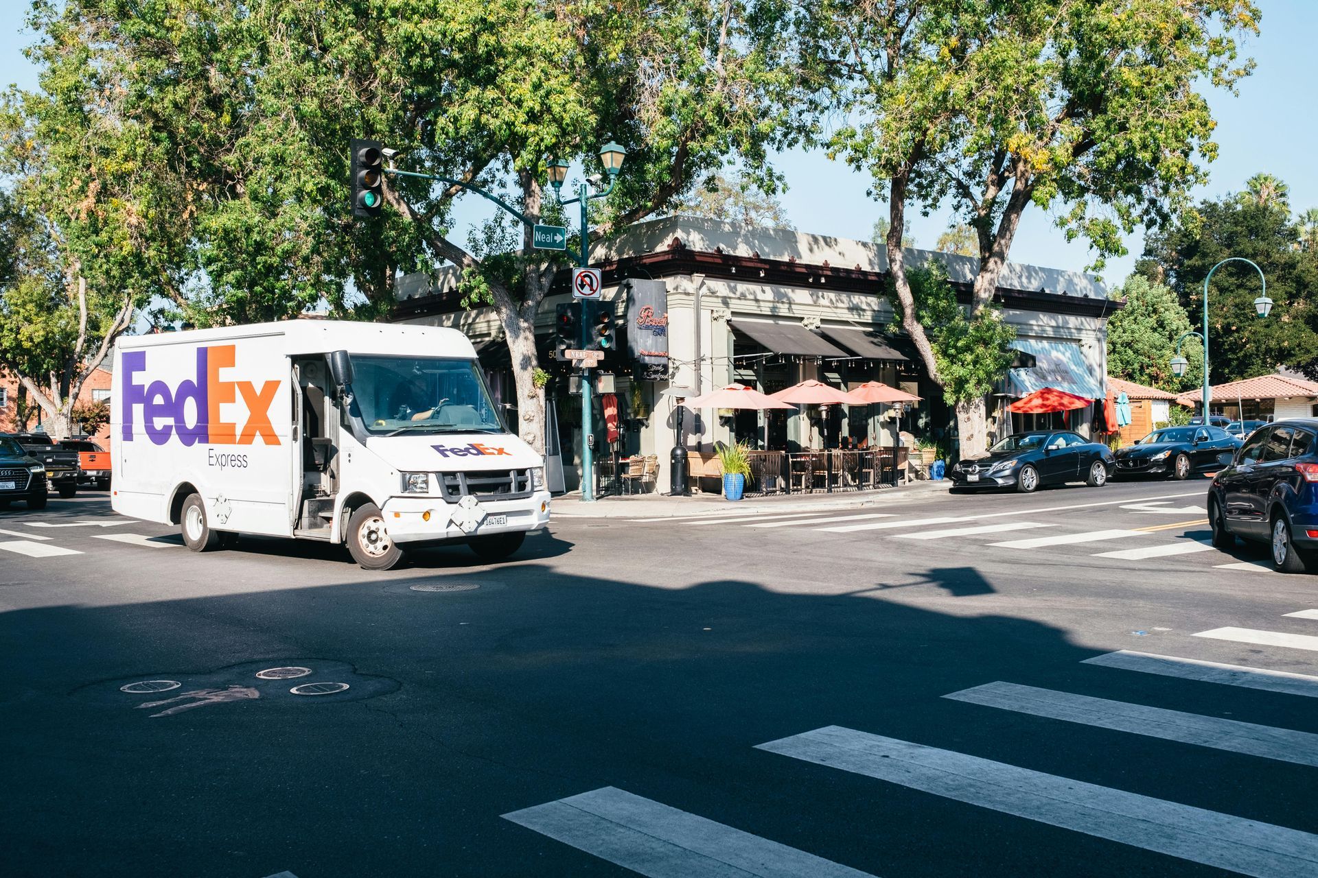 A fedex truck is driving down a city street.