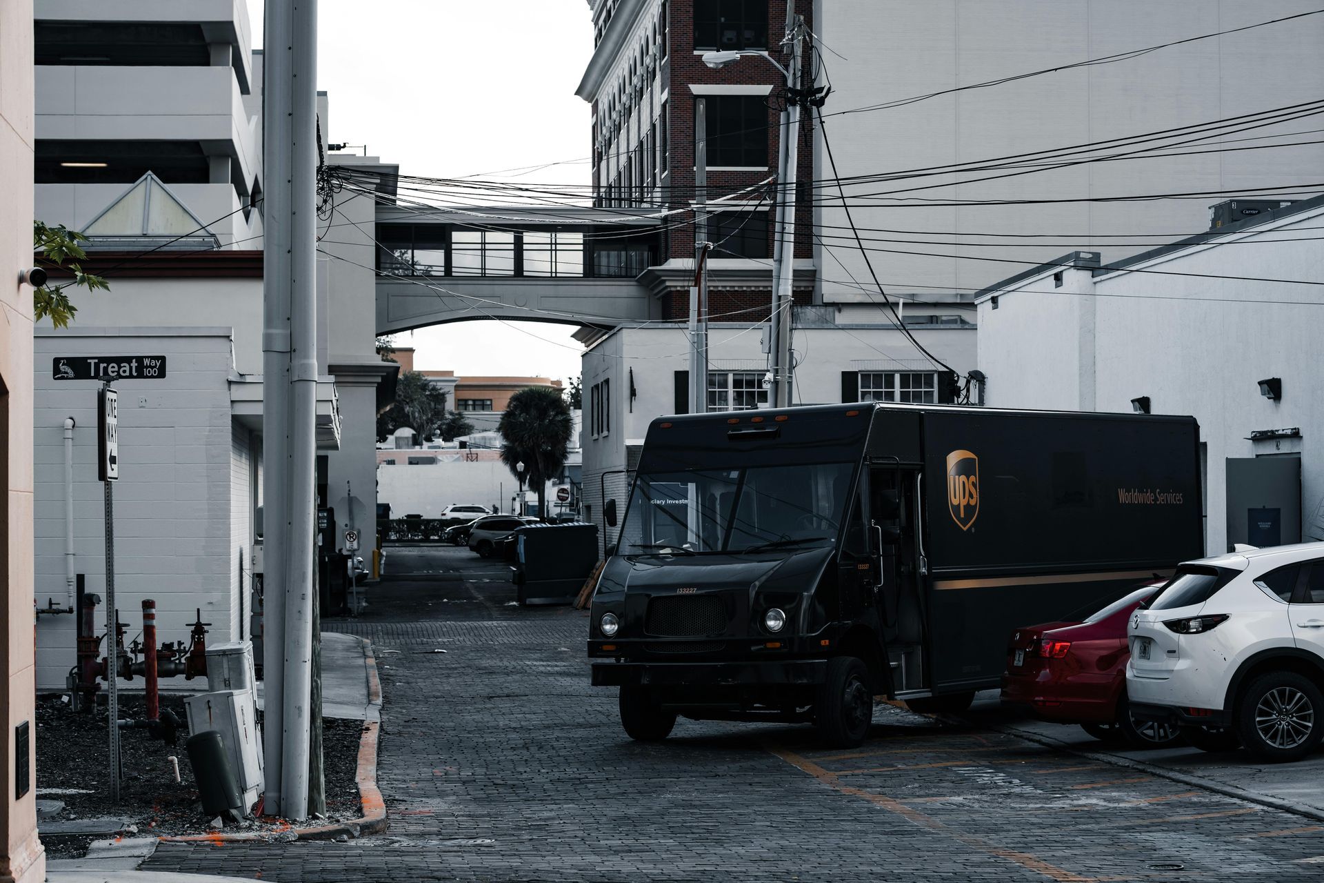 A black ups delivery truck is parked on the side of a city street.