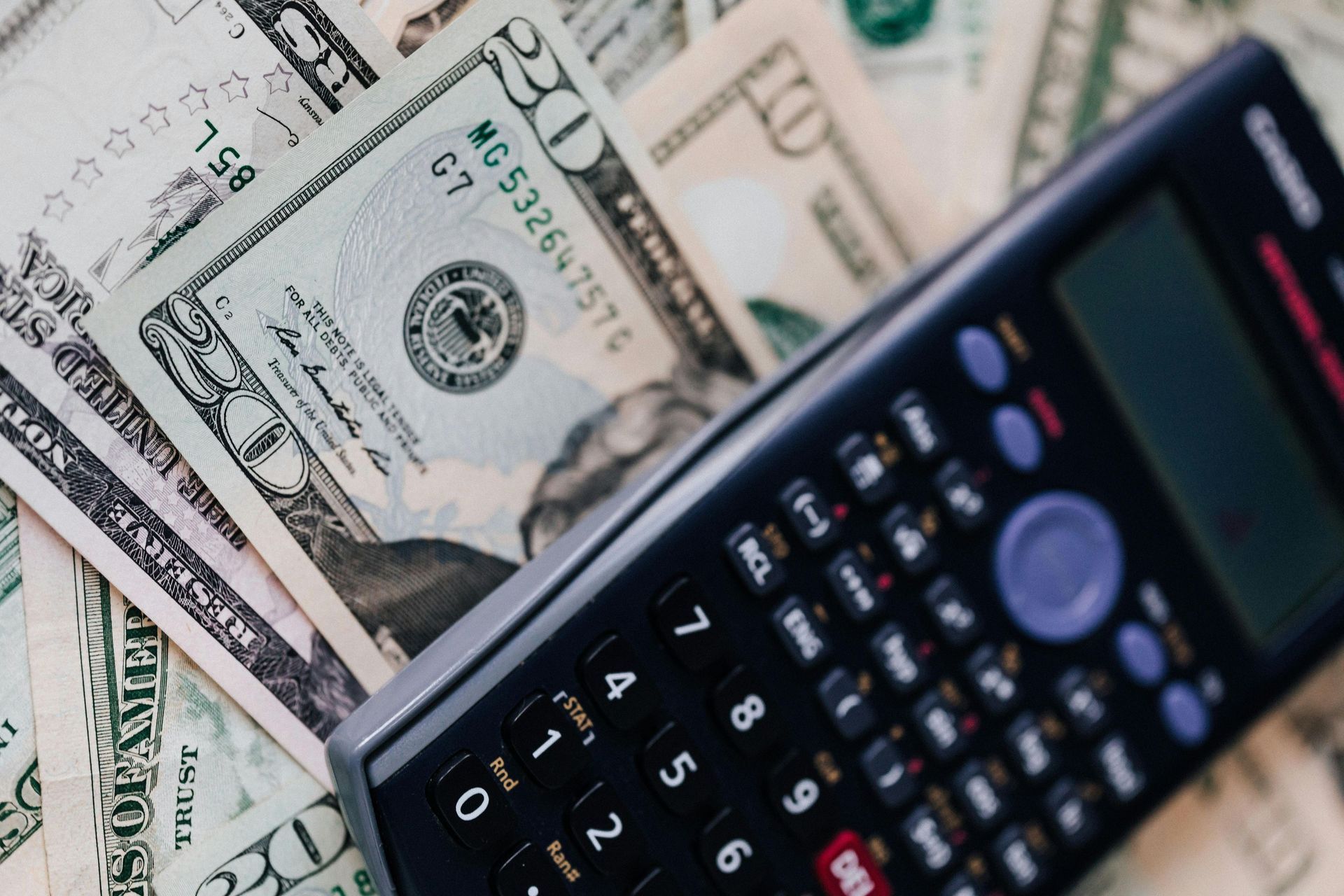 A calculator is sitting on top of a pile of money