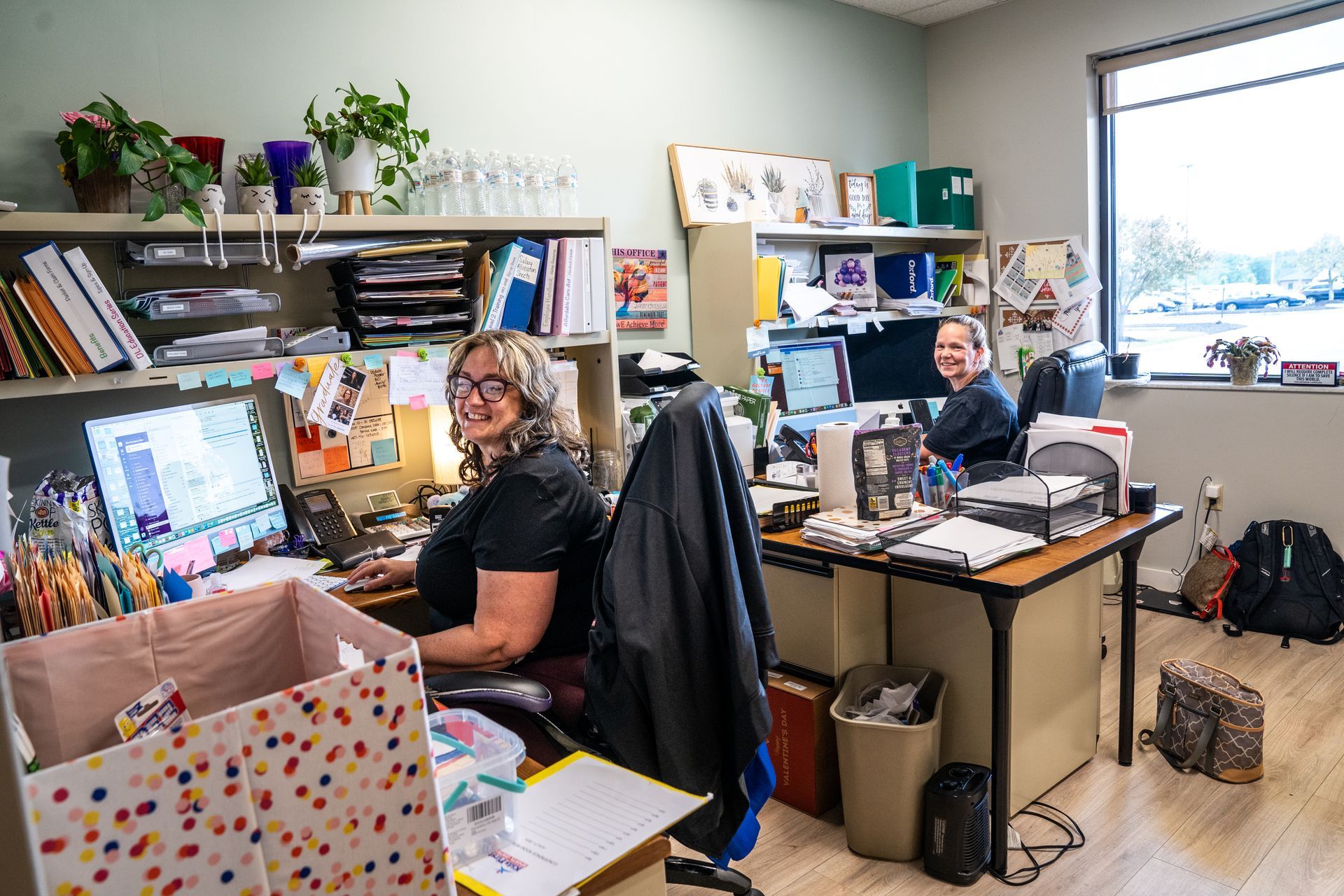 A woman is sitting at a desk in an office.