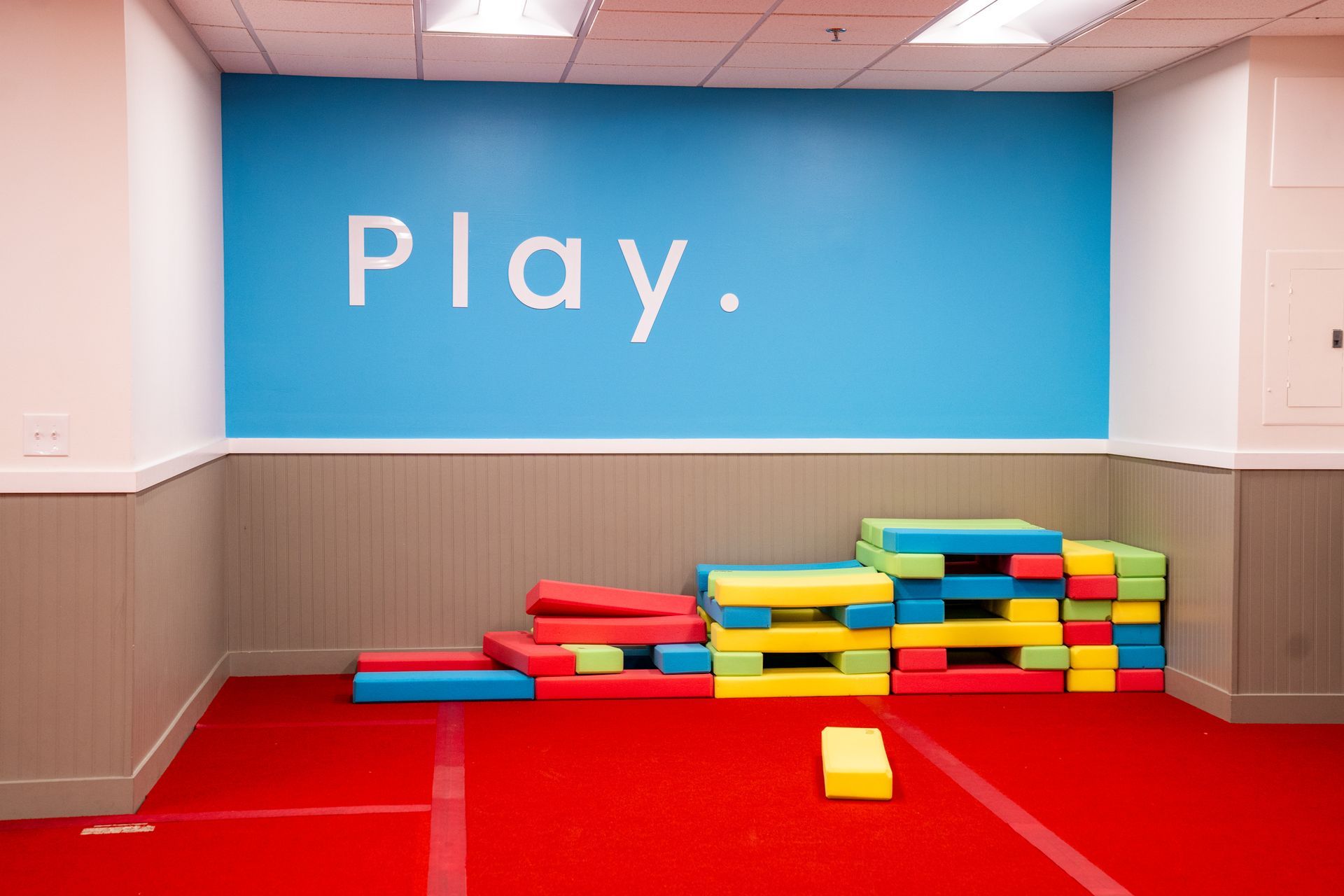 A play area with a bright red floor, blue wall with 