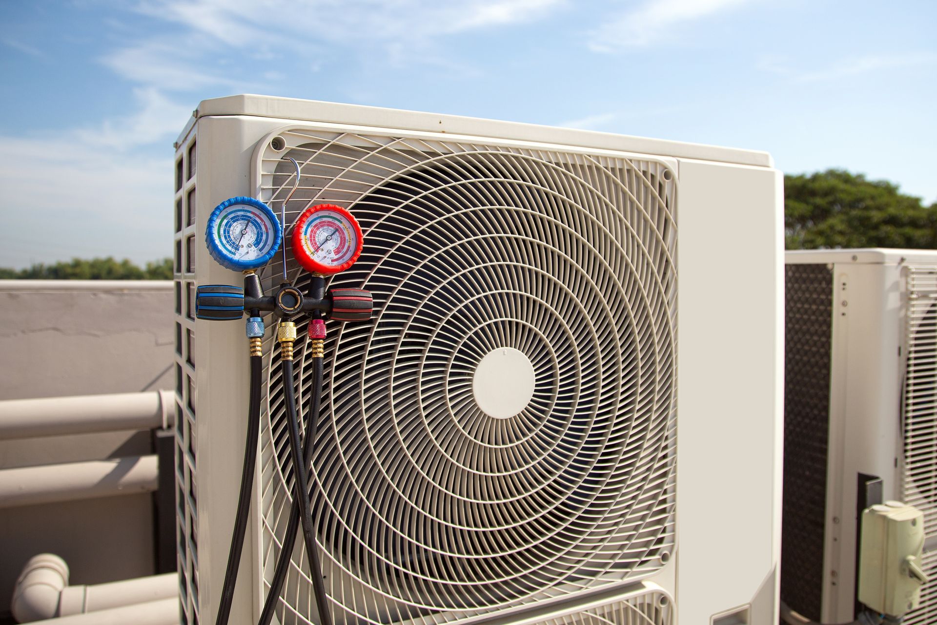 HVAC unit with two gauges attached to the front grille outdoors