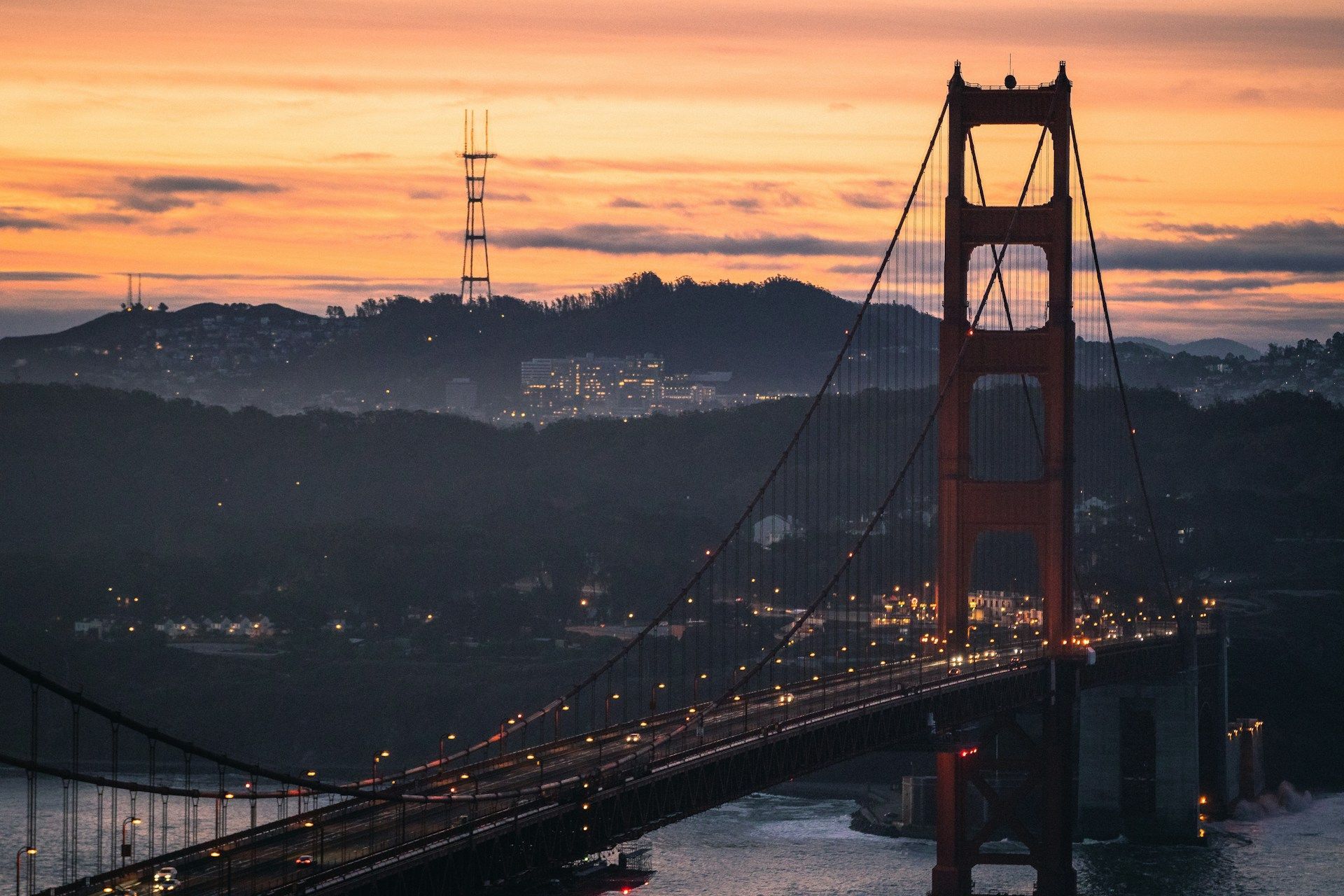 A bridge over a body of water with a sunset in the background.