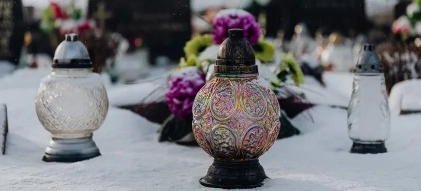 Memorial lanterns and flowers resting on a snowy gravesite, reflecting dignified remembrance and compassionate cremation services Clearwater, FL.
