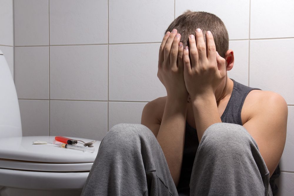 A Man And A Woman Are Holding Hands While Sitting Down — Noosa Psychological Services in Noosa Heads, QLD