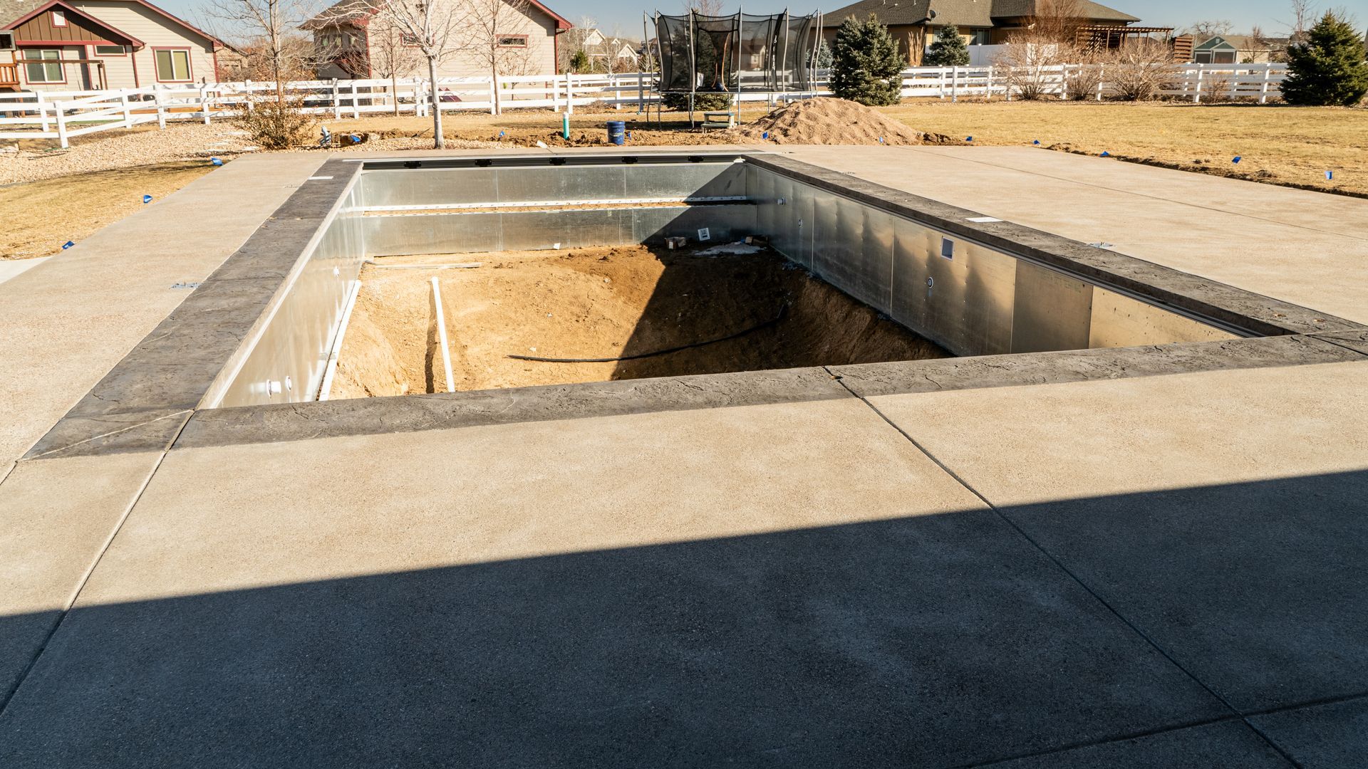 Empty concrete pool under construction in a sunny outdoor area